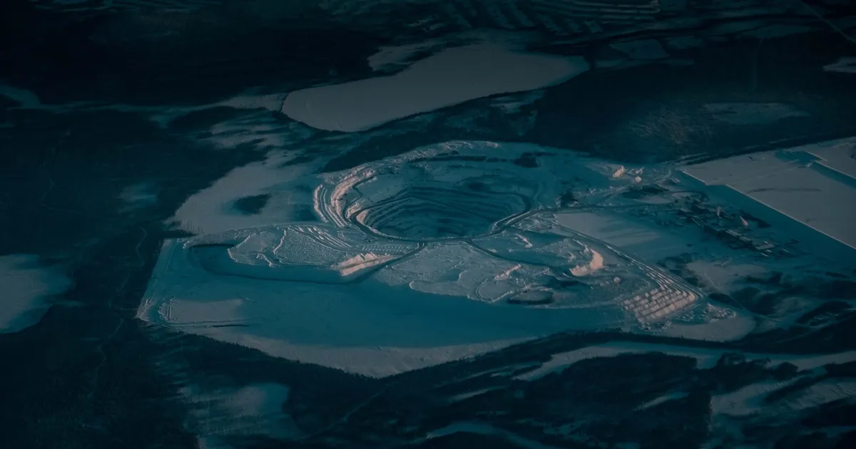 Picturesque drone view of rocky steps at open pit mine covered with snow in industrial terrain in evening
