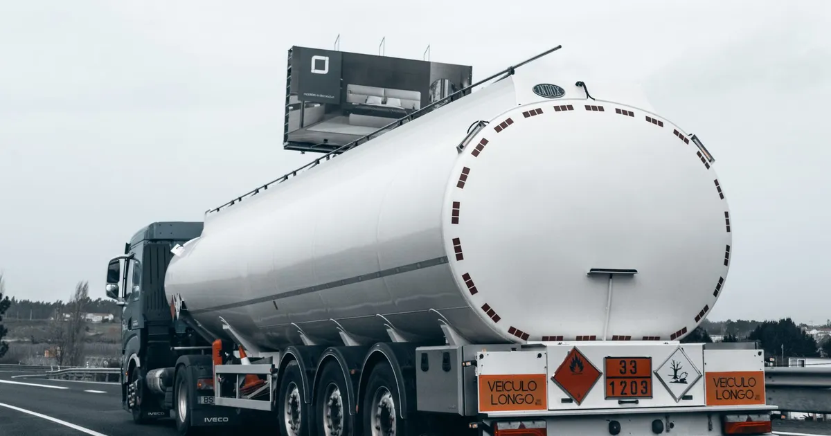 Rear view of a large tanker truck transporting fuel on a highway, emphasizing logistics and transportation.