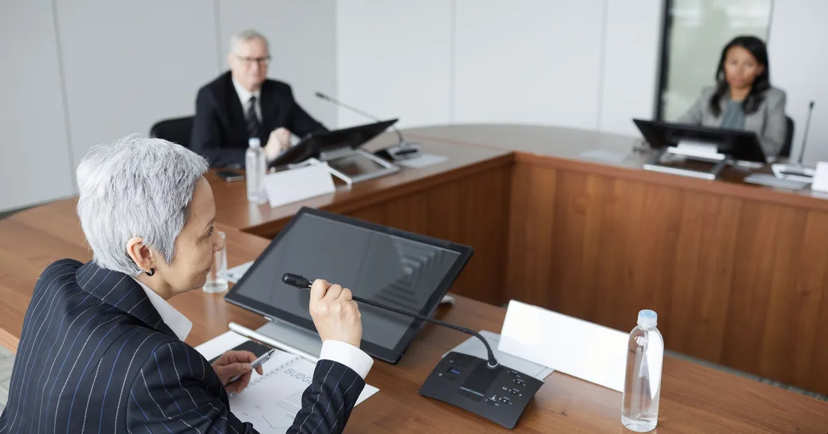 Senior executives discussing strategies in a modern boardroom setting.