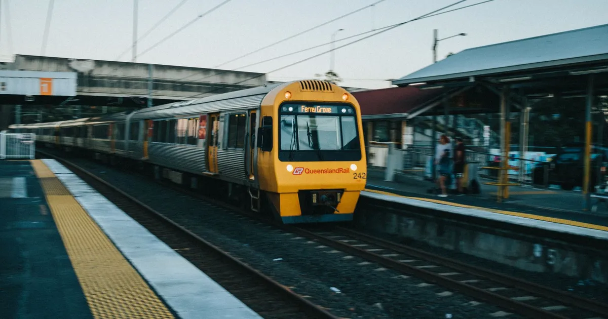 Queensland Rail train arrives at Loganlea Station in Queensland, Australia, showcasing public transport.