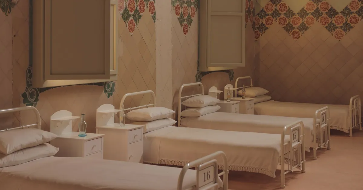 A serene and vintage hospital ward with empty beds in Barcelona.