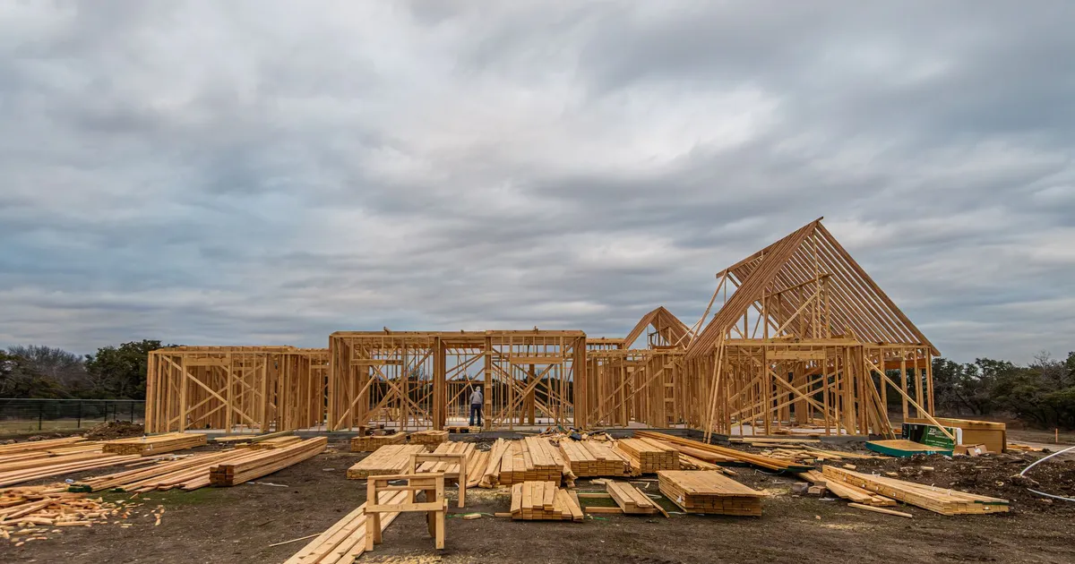 Wooden house framing under construction in Fort Worth, TX during a cloudy day.