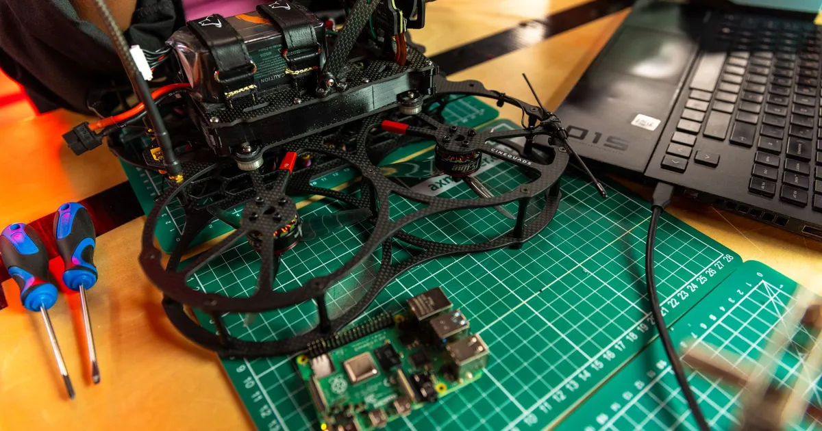 Drone assembly on a desk with laptop and tools, capturing modern tech.