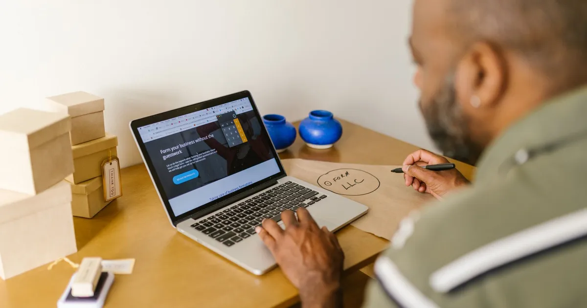 Entrepreneur at a desk using a laptop for business planning. Ideal for tech and startup themes.