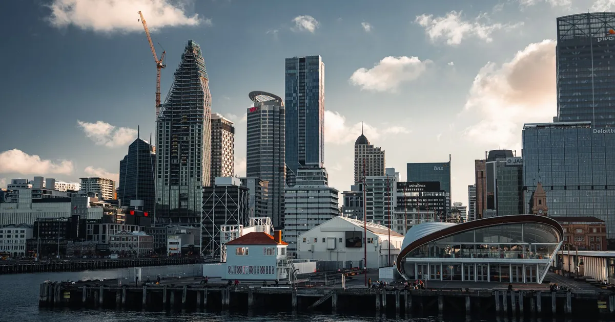 Explore the modern skyline of Auckland with its iconic waterfront view featuring skyscrapers and a tranquil harbor.