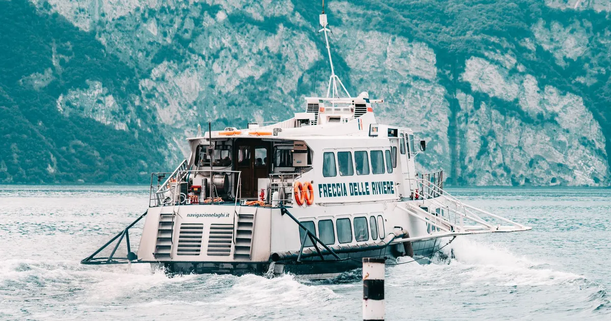 Passenger ferry traverses scenic mountain lake, offering a picturesque travel experience.