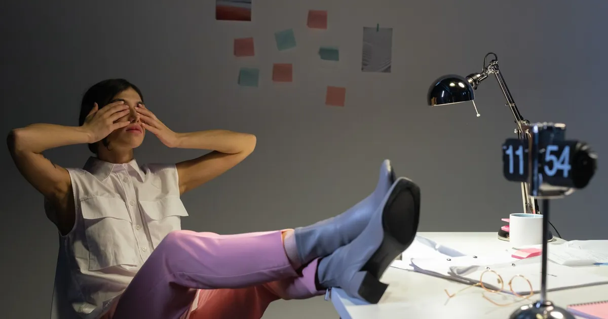 Overworked woman takes a break at her desk, showing exhaustion and relaxation