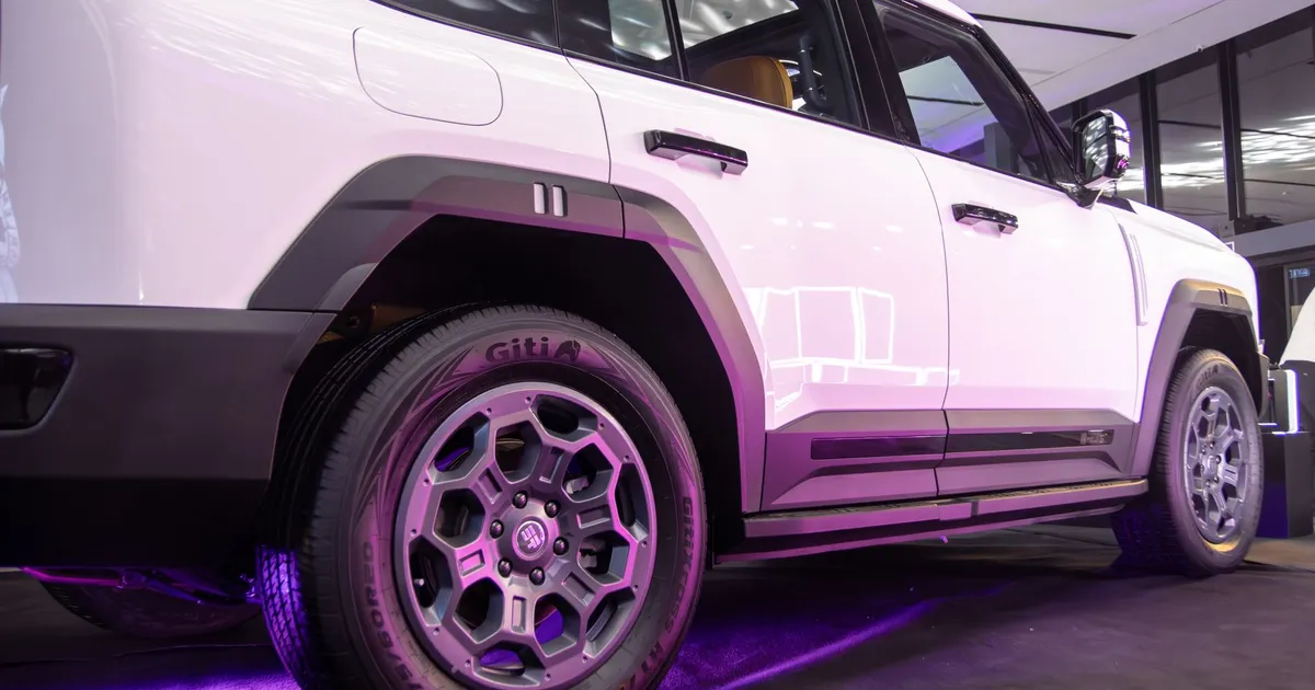 Modern SUV showcased indoors with stylish purple lighting, highlighting its sleek design.