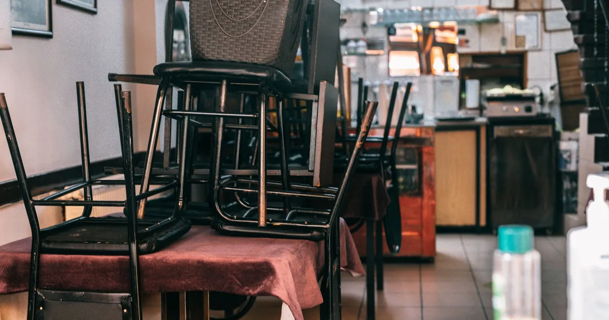 Modern cafe with kitchen and chairs on table before closing and prepared for cleaning