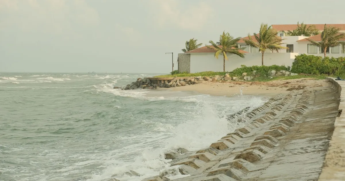 Beautiful coastal scene in Hội An, Vietnam showing waves crashing against the seawall.