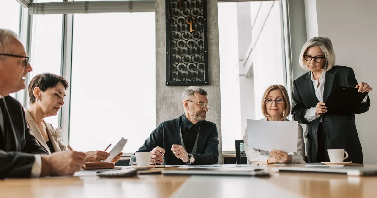 Business professionals discussing documents in a modern meeting room.