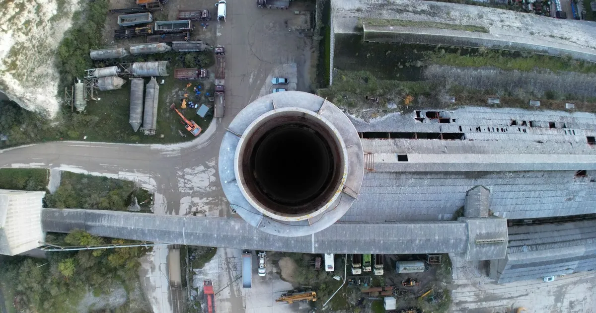 Drone shot capturing an aerial view of industrial factory and chimney, showcasing industrial infrastructure.