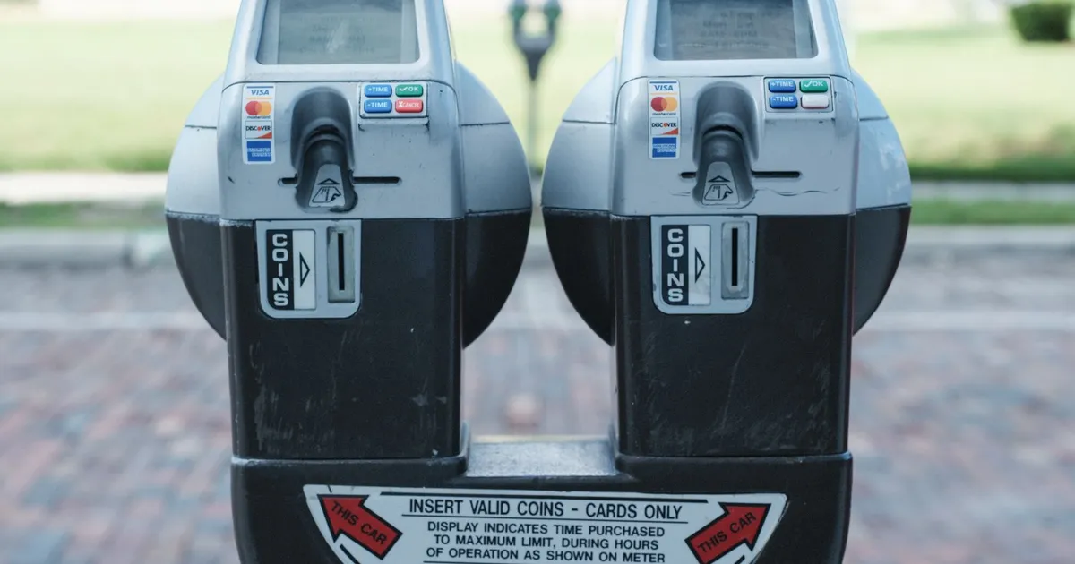 Photo of two parking meters in Orlando showing coin and card payment options on a brick road.