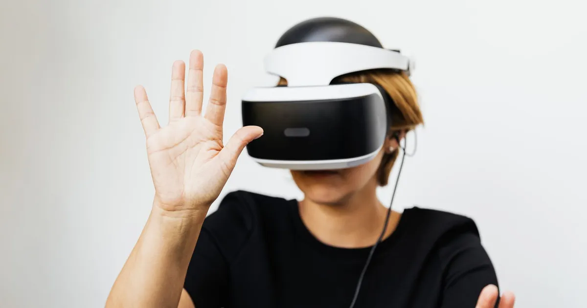 Woman experiencing virtual reality with VR headset on white background.