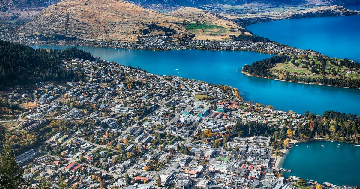 Breathtaking aerial view of Queenstown, New Zealand with lake and mountains.