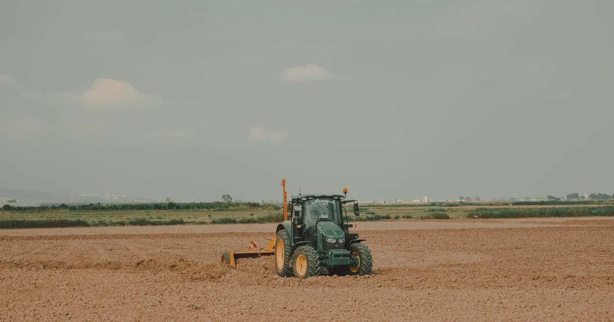 A tractor working on a vast field in the rural landscapes of Mersin, Türkiye.