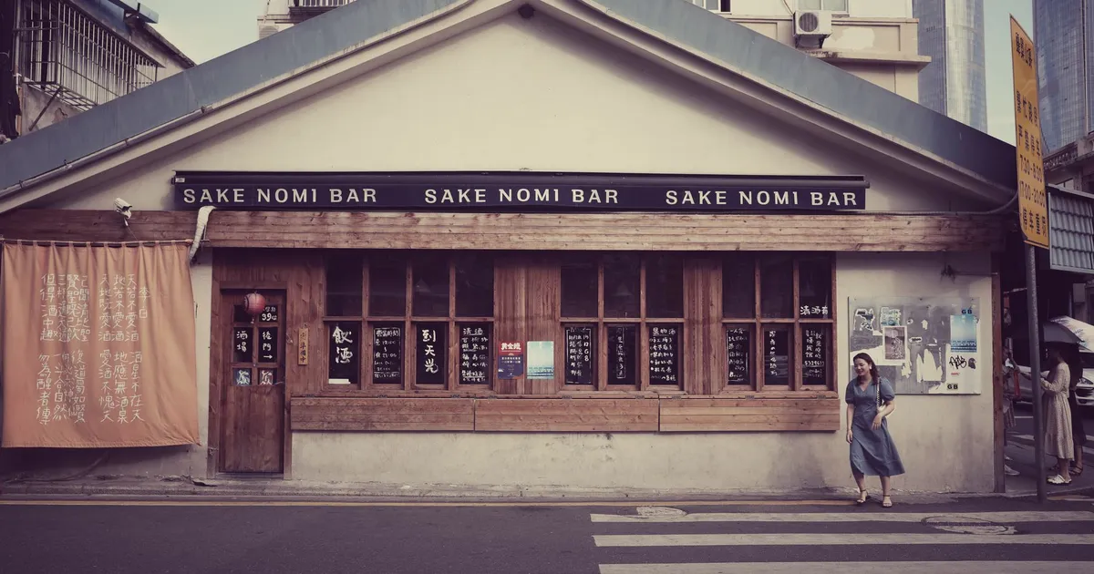 Picturesque street view of Sake Nomi Bar facade, featuring traditional architecture and urban scene.