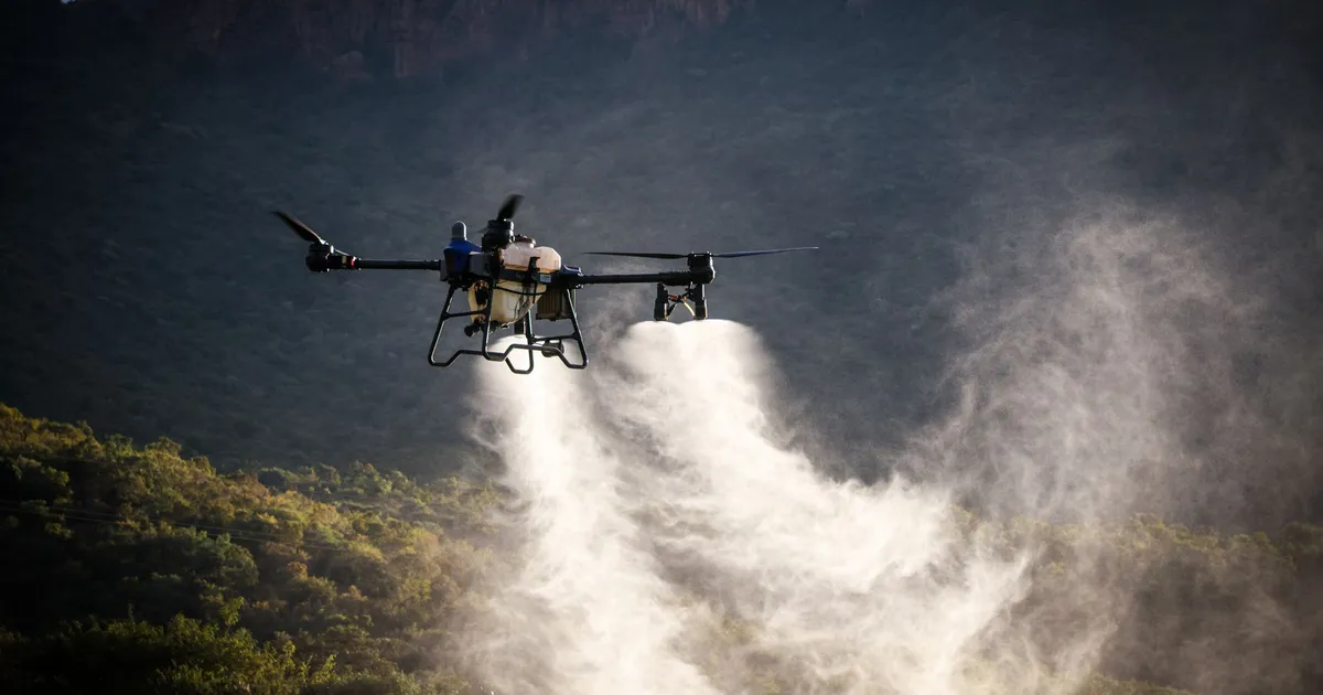 High-tech drone disperses pesticide over mountains, illustrating agricultural innovation.