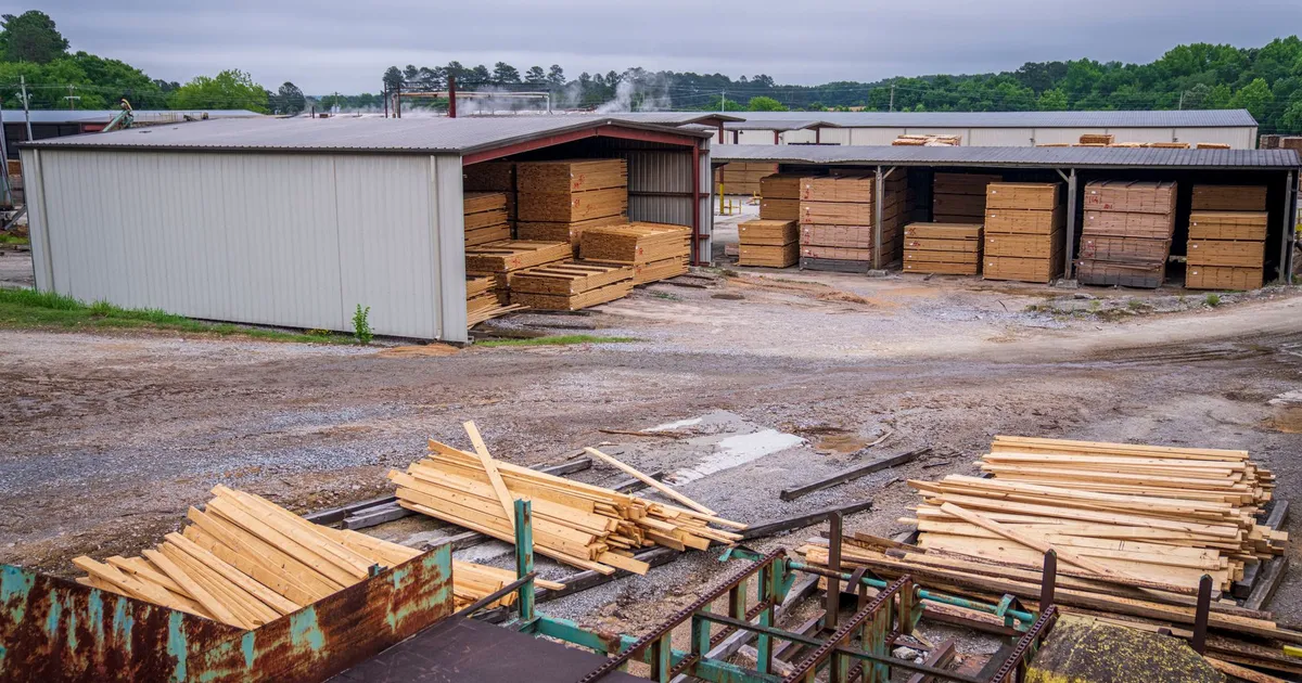 A comprehensive view of an industrial lumber yard showcasing neatly stacked wood planks ready for distribution.