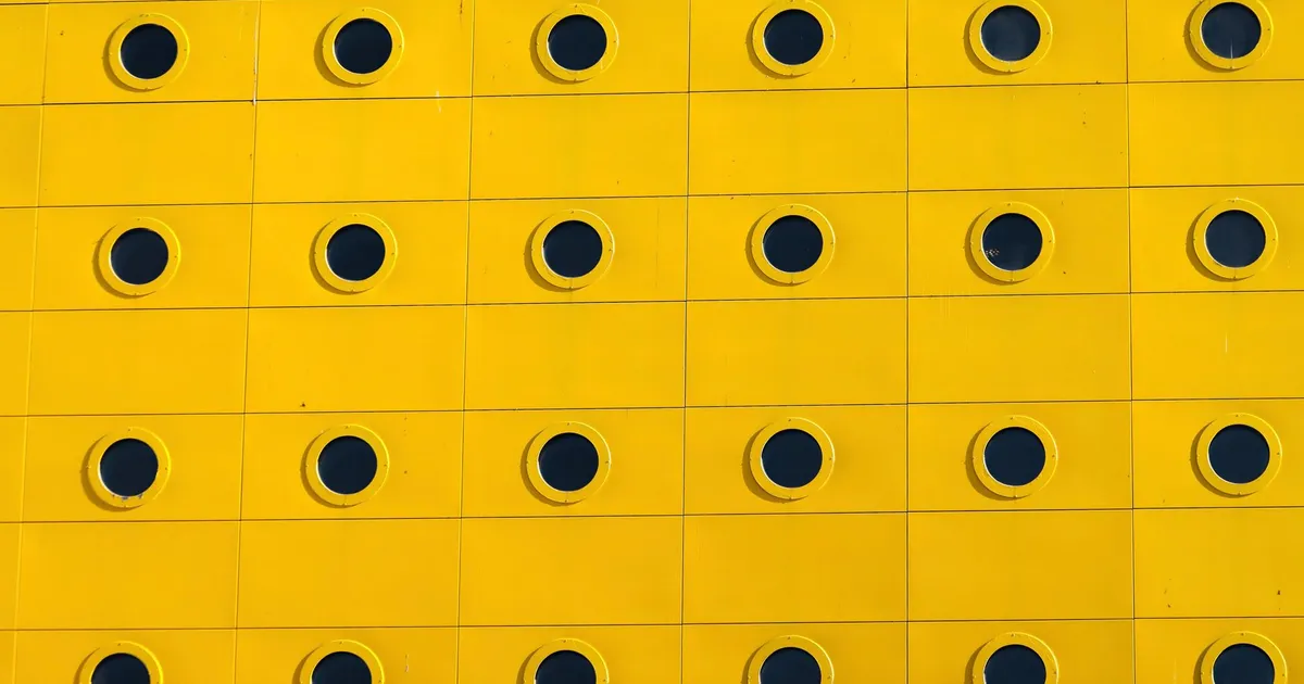 Abstract yellow facade with circular patterns in Jönköping, Sweden, showcasing modern Scandinavian design.