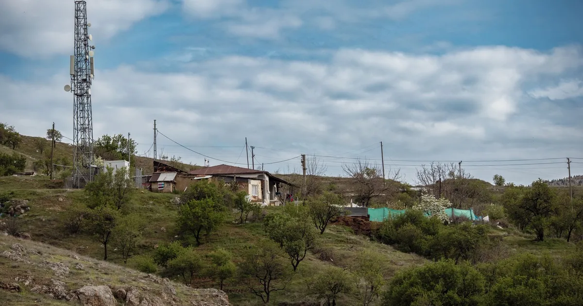 Scenic rural landscape with a cell tower and rustic houses in Elazığ, Türkiye.