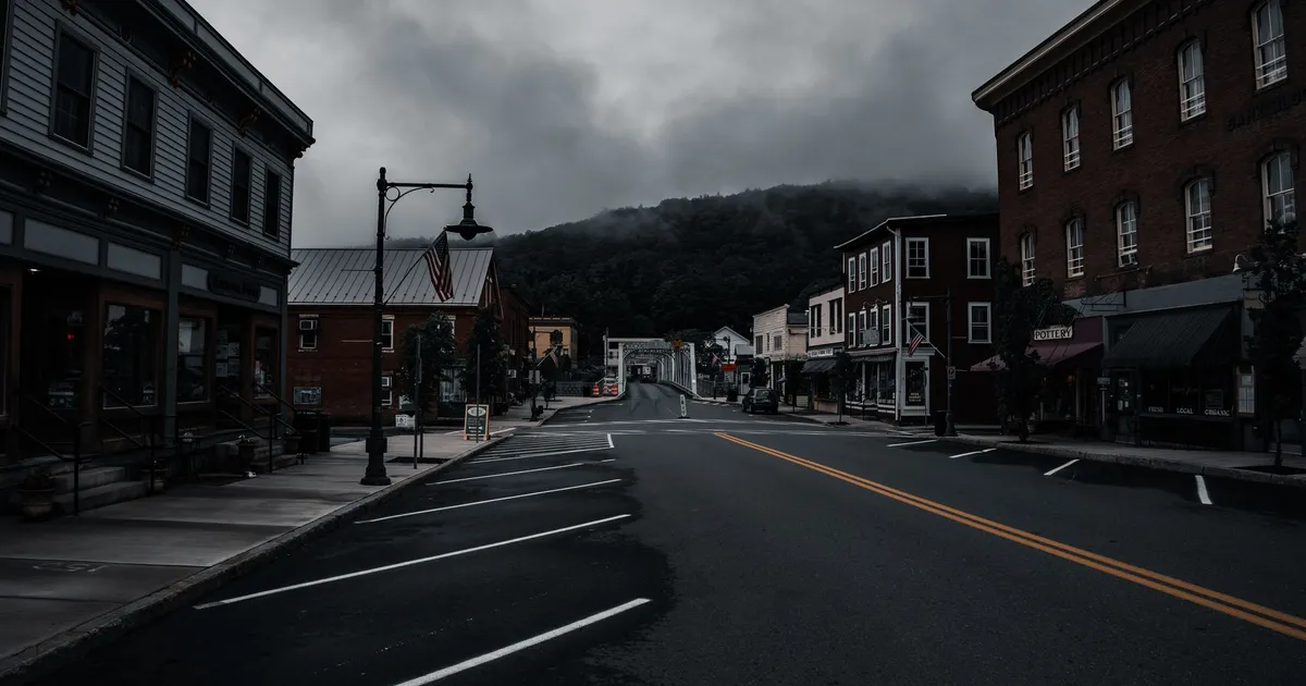 Empty town street with historic buildings and moody clouds. Perfect for travel or urban exploration themes.