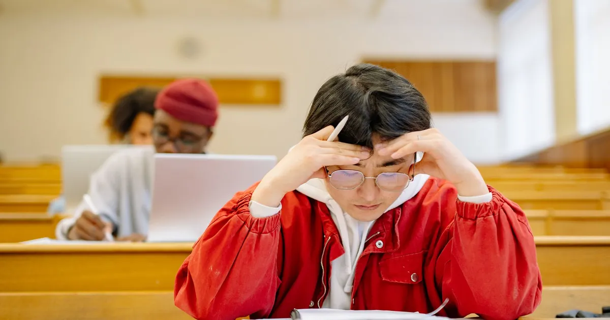 Focused students studying intensely in a university lecture hall setting.