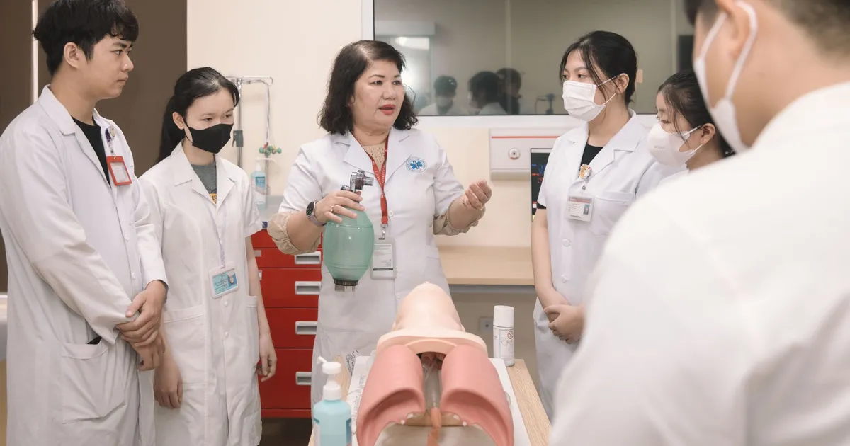 Group of medical students practicing skills with a training mannequin in a classroom setting.