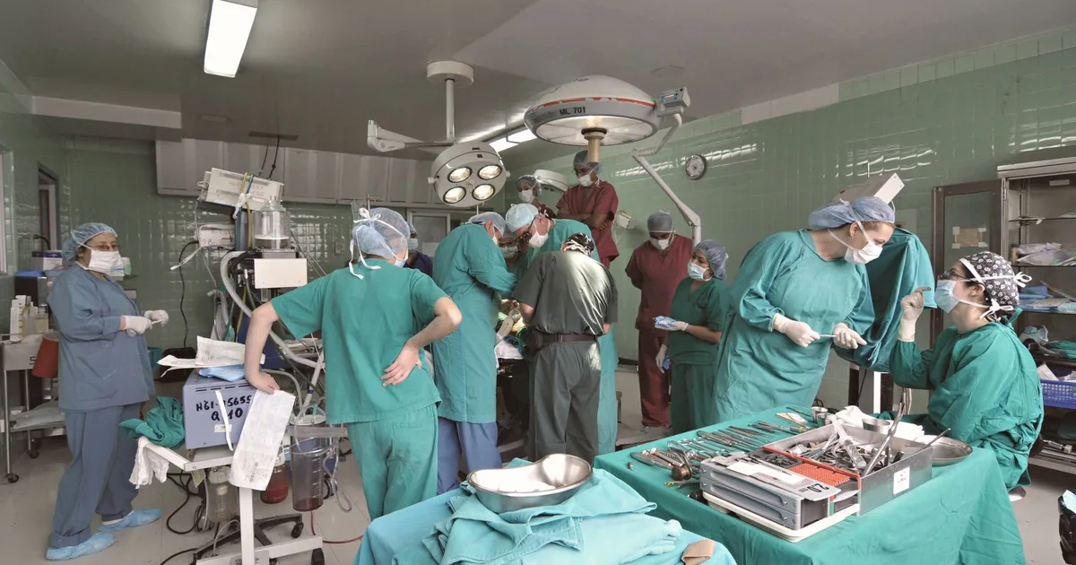 Surgeons and medical staff working together in a hospital operating room during surgery.