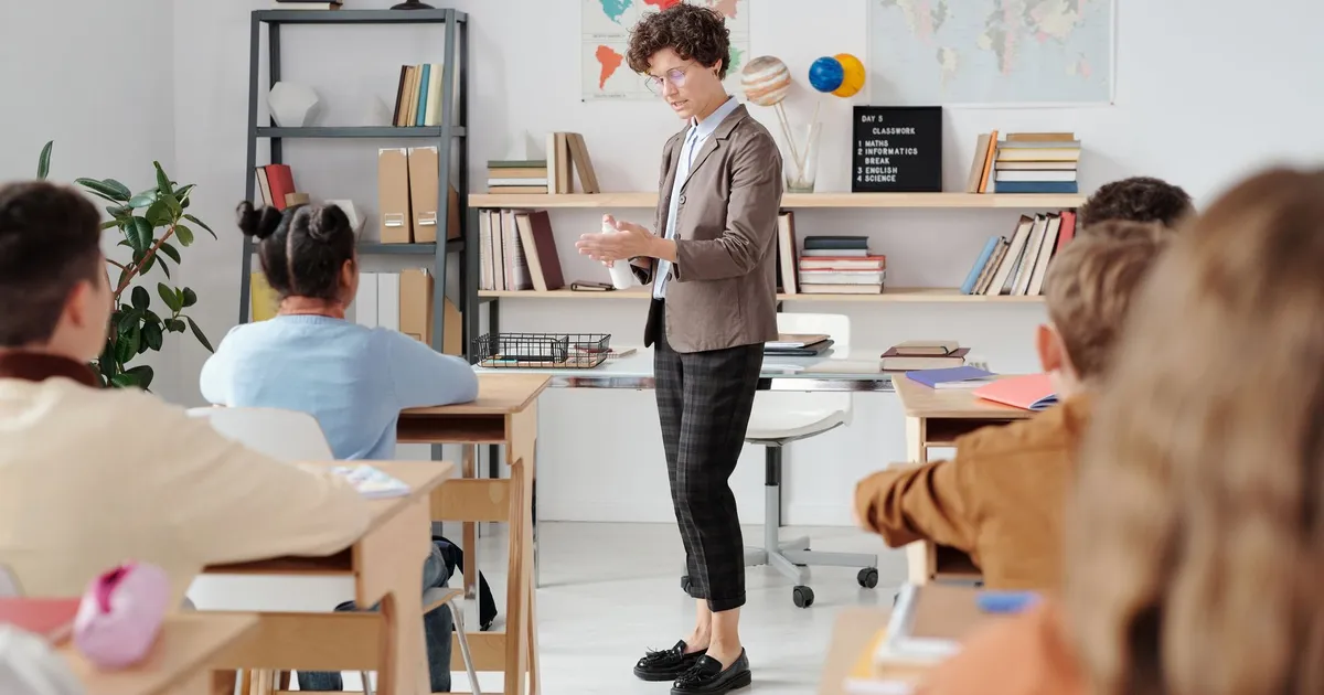 Teacher conducting a classroom lesson with attentive students in a vibrant educational setting.