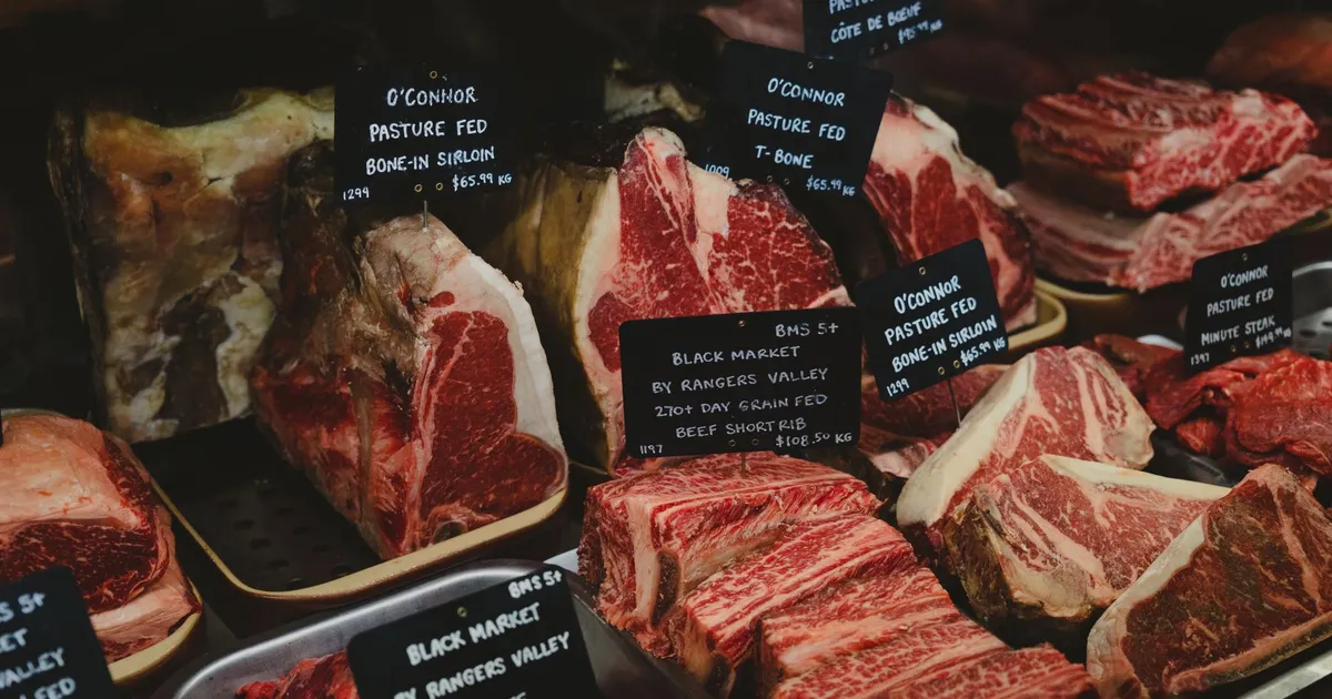 Assorted premium beef cuts with labels showcased in a gourmet market setting.
